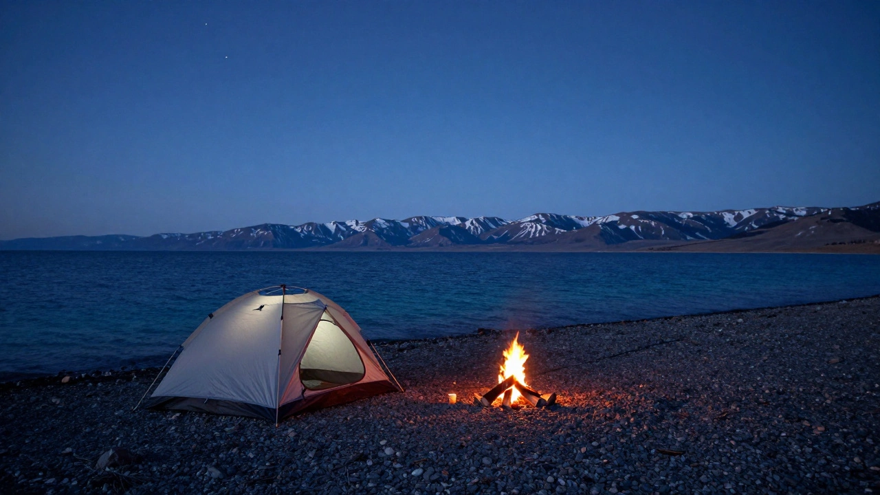 Палатка и костер на берегу озера Байкал на фоне гор в сумерках